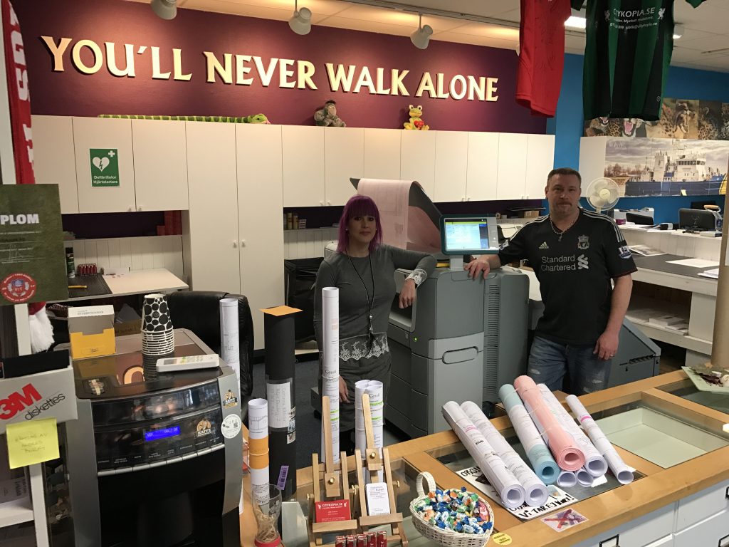 Citykopias butik med personal, kopieringsmaskiner och ritningsrullar